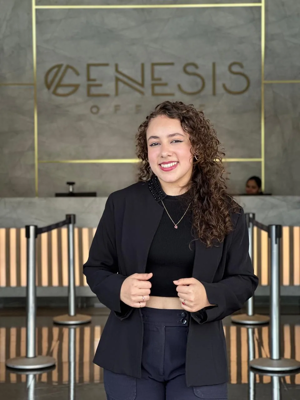 Maria Fernanda em traje profissional no hall do Genesis Office.